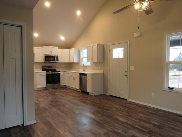 kitchen featuring dark wood-style floors, stainless steel appliances, light countertops, white cabinets, and baseboards