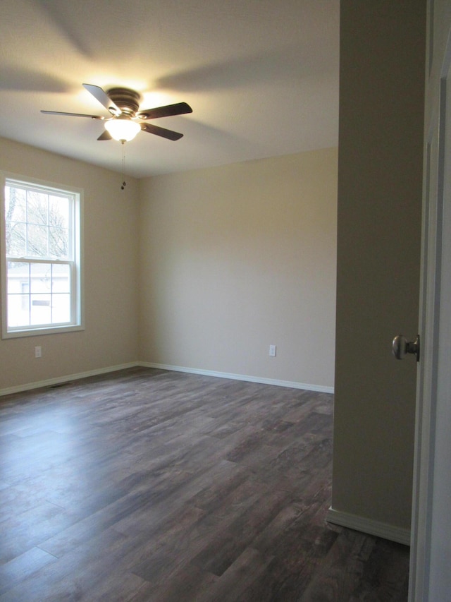 spare room featuring dark wood-style floors, baseboards, and a ceiling fan