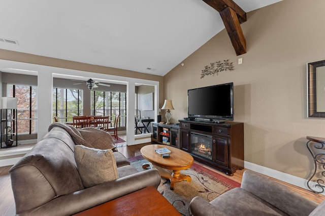 living area featuring wood finished floors, baseboards, visible vents, vaulted ceiling with beams, and ceiling fan