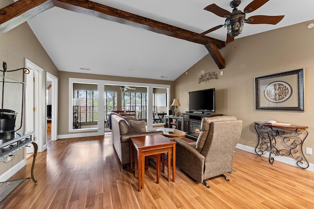 living area with visible vents, lofted ceiling with beams, ceiling fan, and wood finished floors