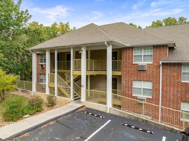 view of property featuring stairway and uncovered parking