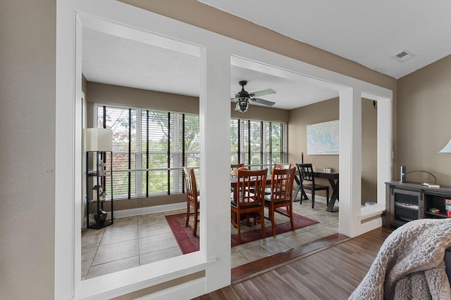 dining space featuring baseboards, a ceiling fan, and wood finished floors