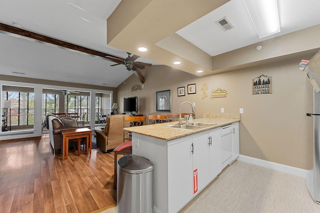 kitchen featuring visible vents, vaulted ceiling with beams, ceiling fan, a peninsula, and a sink