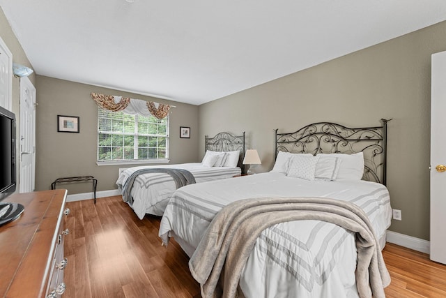 bedroom with baseboards and wood finished floors