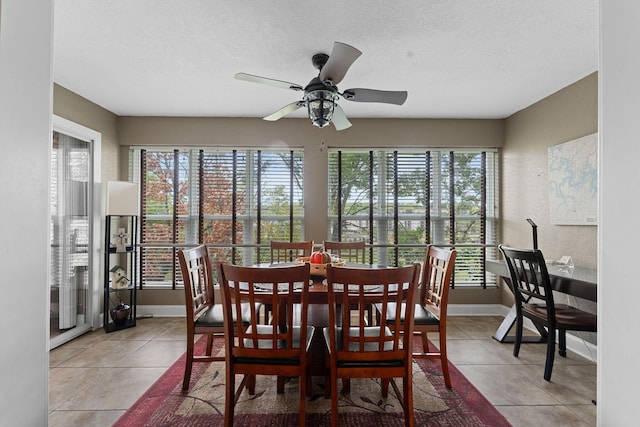 tiled dining space featuring a wealth of natural light, baseboards, a textured ceiling, and ceiling fan