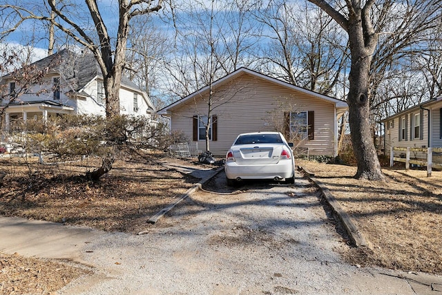 view of side of home featuring gravel driveway