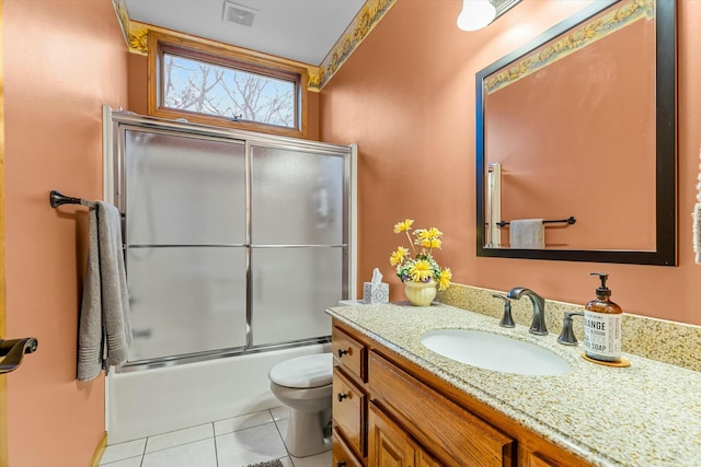 bathroom with visible vents, toilet, shower / bath combination with glass door, tile patterned floors, and vanity