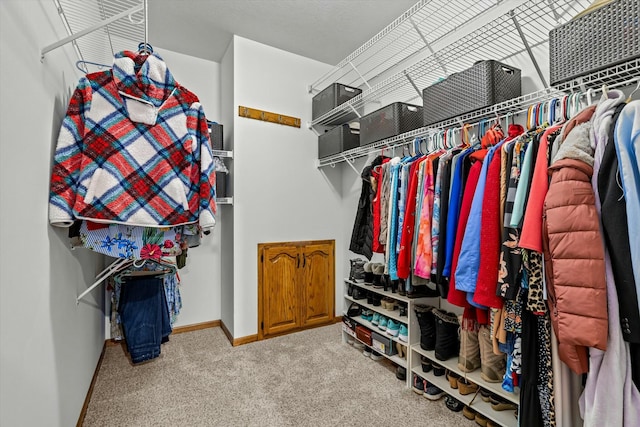 walk in closet with carpet flooring