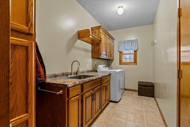 laundry area featuring light tile patterned floors, a sink, baseboards, cabinet space, and washer and clothes dryer