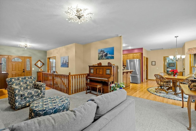 living area with light wood finished floors and an inviting chandelier