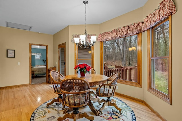 dining room featuring light wood-type flooring, baseboards, and a chandelier