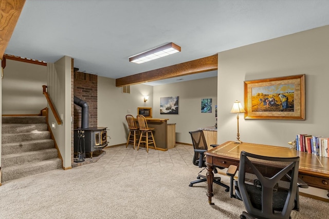 carpeted home office with a wood stove, baseboards, a bar, and beam ceiling