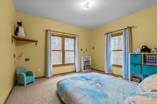 carpeted bedroom with visible vents, a textured ceiling, and baseboards