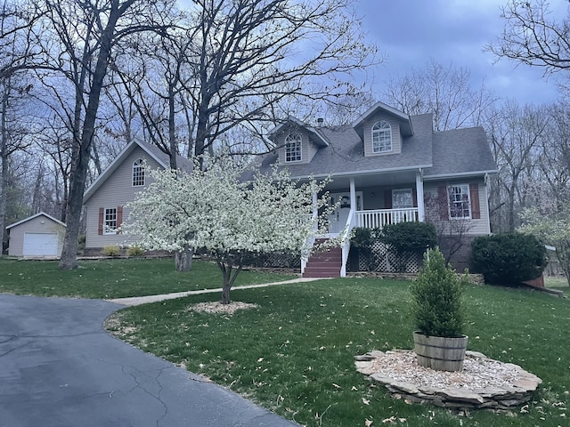 view of front of property featuring a garage, a shingled roof, an outdoor structure, a porch, and a front yard