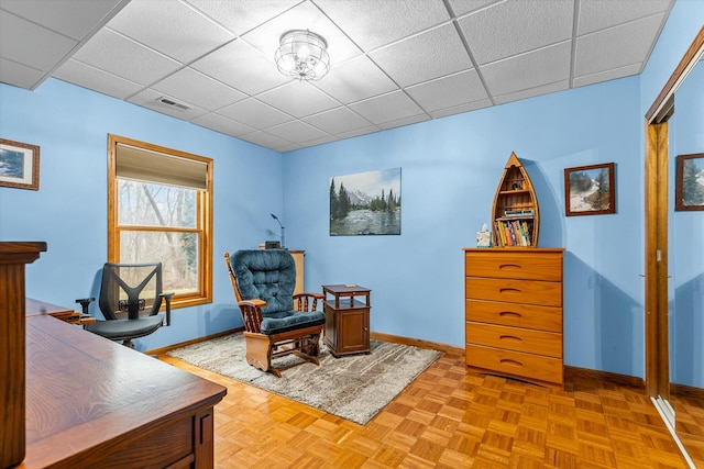 office with a paneled ceiling, visible vents, and baseboards