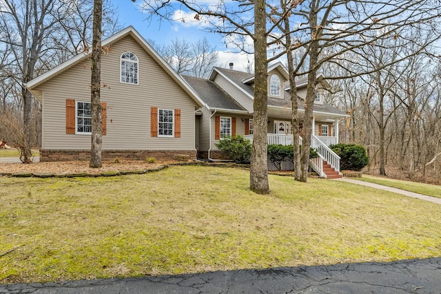 view of front of house featuring covered porch, a front lawn, and roof with shingles