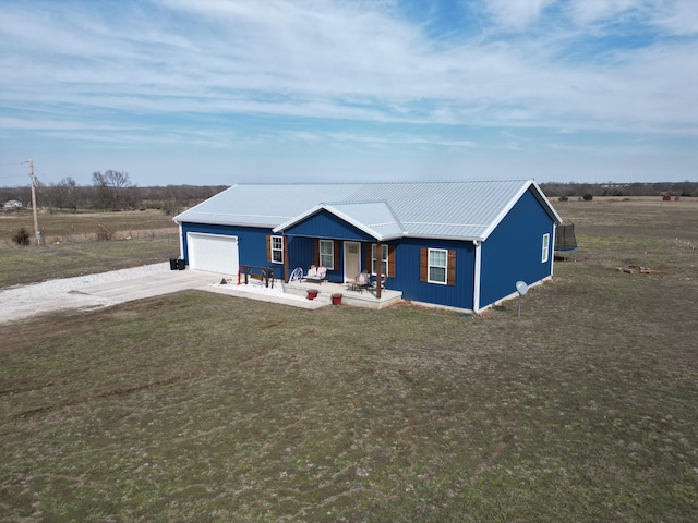 view of front of home with driveway, a porch, metal roof, an attached garage, and a front lawn