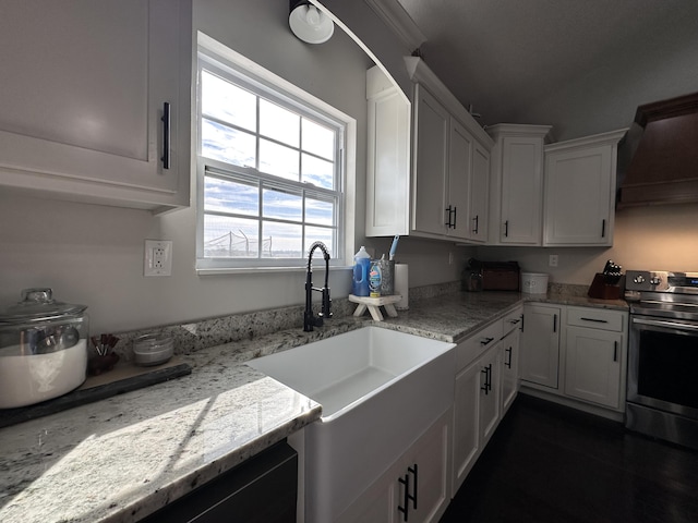 kitchen with premium range hood, electric range, a sink, and white cabinets