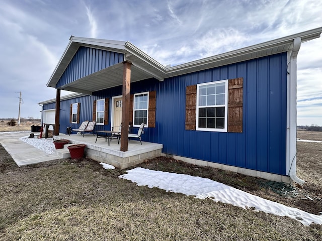 back of house with a patio area and board and batten siding