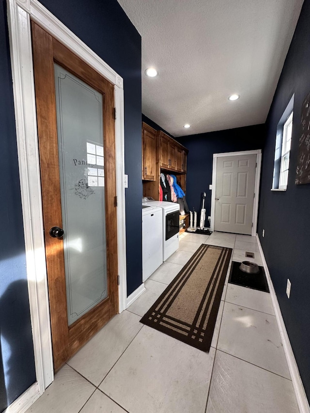 laundry room with light tile patterned floors, recessed lighting, baseboards, independent washer and dryer, and cabinet space