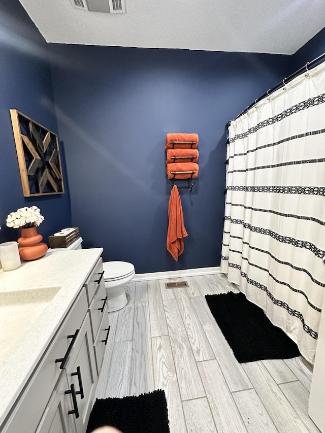 full bathroom with visible vents, wood finish floors, vanity, and baseboards