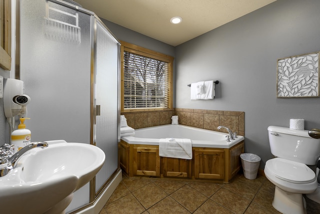 full bath featuring toilet, a sink, tile patterned flooring, a shower stall, and a bath