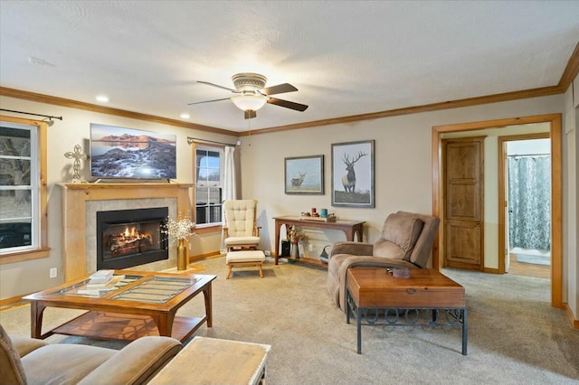 living area featuring a fireplace, ornamental molding, a ceiling fan, light carpet, and baseboards