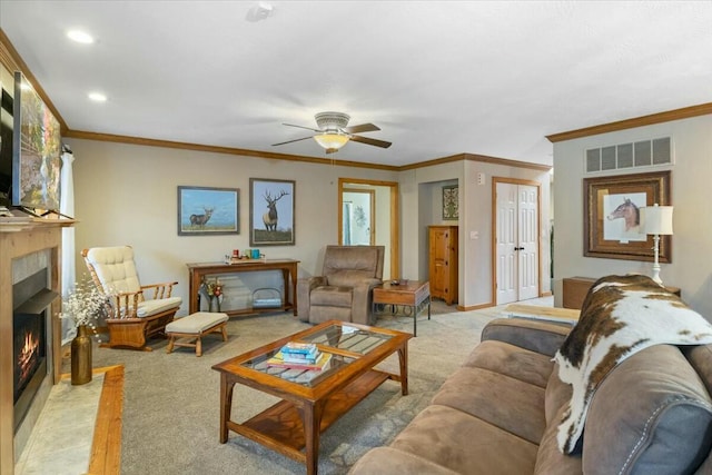 living room featuring visible vents, light colored carpet, a fireplace with flush hearth, ceiling fan, and crown molding