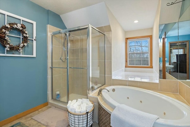 bathroom with a shower stall, a tub with jets, and baseboards