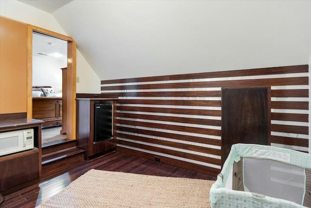 interior space featuring lofted ceiling, dark wood-style floors, wine cooler, and wood walls