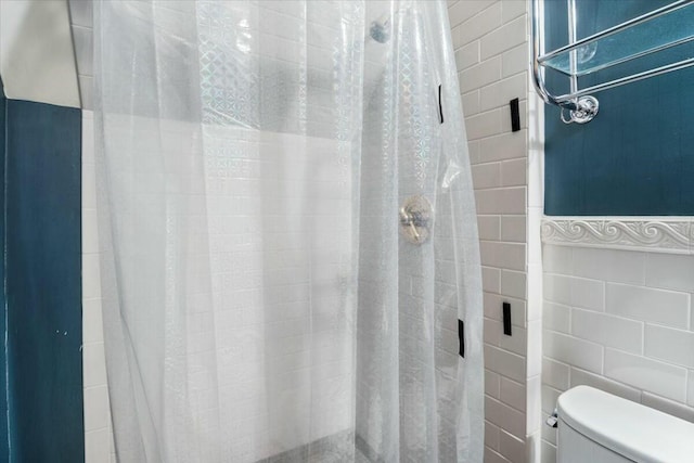 full bathroom featuring toilet, a shower stall, and tile walls