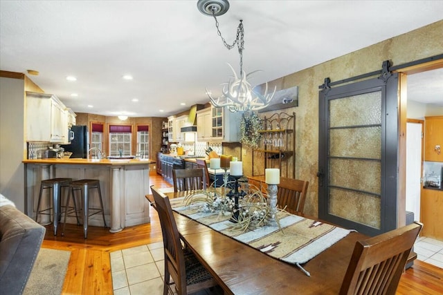 dining room featuring light wood-type flooring, a chandelier, and recessed lighting