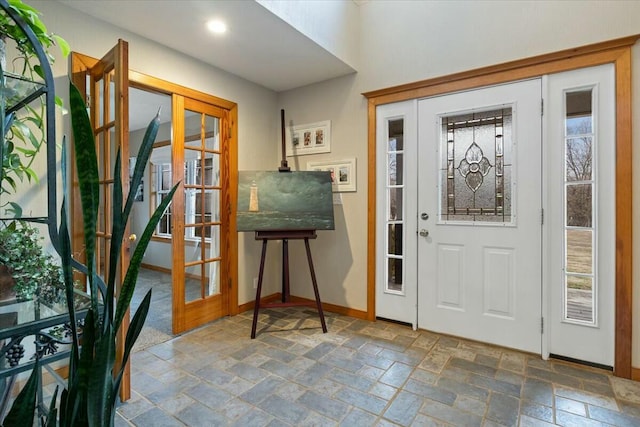 foyer entrance with stone tile flooring and baseboards