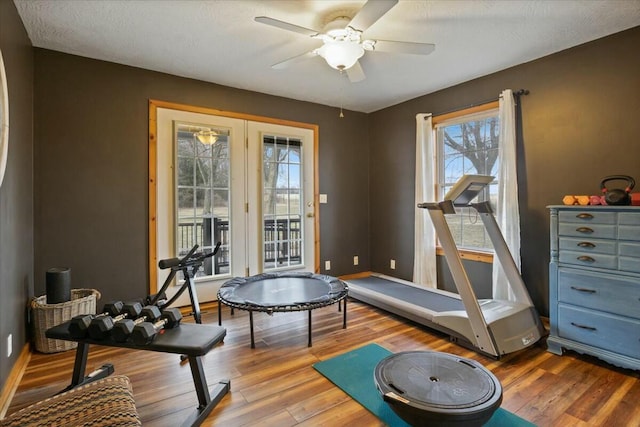 workout room featuring ceiling fan, baseboards, and wood finished floors