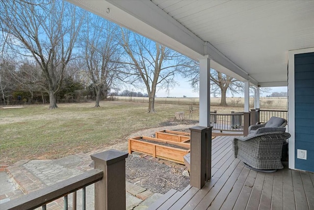 wooden terrace with a rural view and a lawn