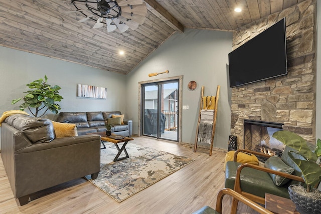 living room with wooden ceiling, ceiling fan, wood finished floors, a stone fireplace, and high vaulted ceiling