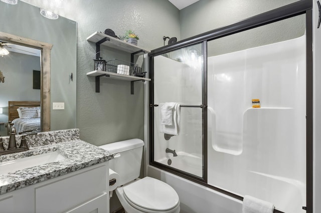 ensuite bathroom featuring connected bathroom, a textured wall, toilet, enclosed tub / shower combo, and vanity