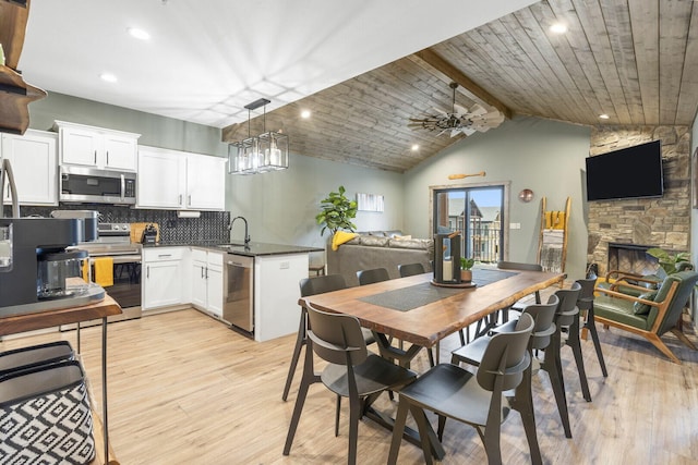 kitchen featuring light wood-type flooring, a peninsula, stainless steel appliances, and open floor plan