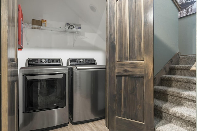 laundry area featuring laundry area, washing machine and dryer, and light wood-style floors