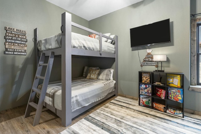 bedroom with baseboards and wood finished floors