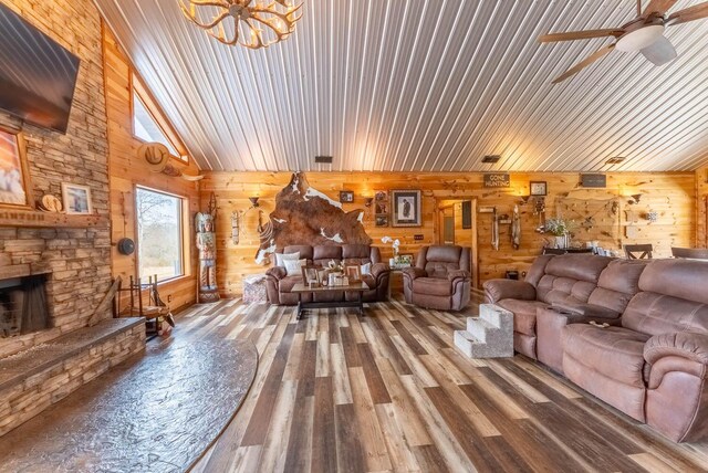 80 Serenity Ct, Gepp, AR 72538 - living room featuring wooden walls, a fireplace, wood finished floors, and ceiling fan with notable chandelier