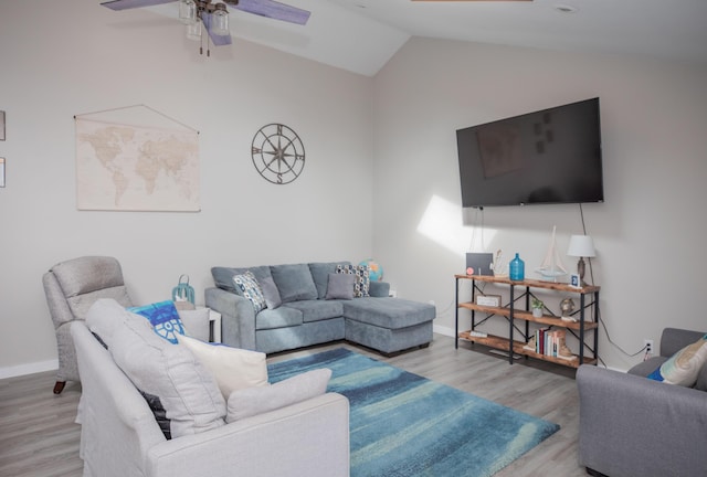 living area with ceiling fan, vaulted ceiling, baseboards, and wood finished floors