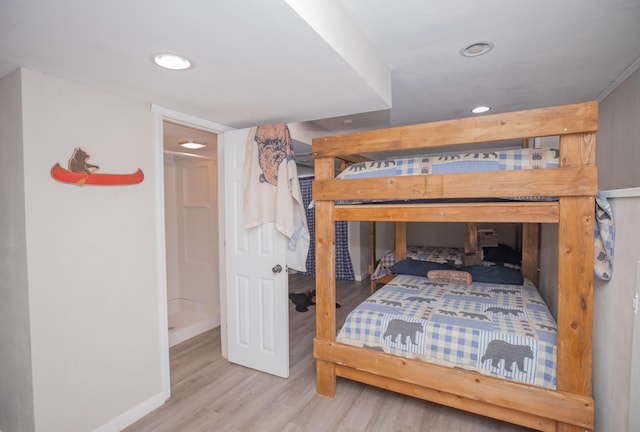 bedroom with baseboards, wood finished floors, and recessed lighting