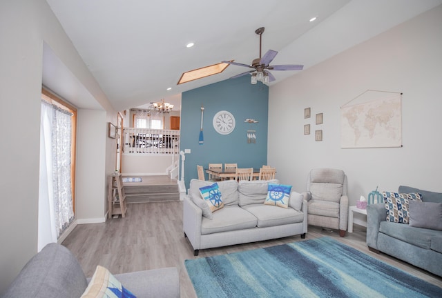 living area with stairs, lofted ceiling, recessed lighting, wood finished floors, and ceiling fan with notable chandelier