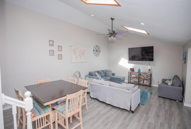 living area featuring recessed lighting, lofted ceiling with skylight, a ceiling fan, light wood-type flooring, and baseboards