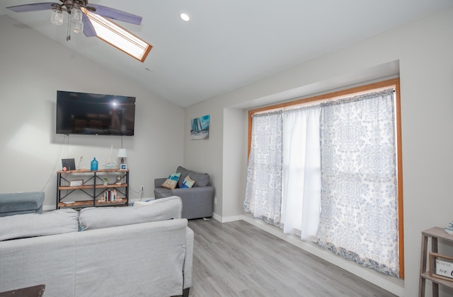 living room with lofted ceiling with skylight, a ceiling fan, recessed lighting, and wood finished floors