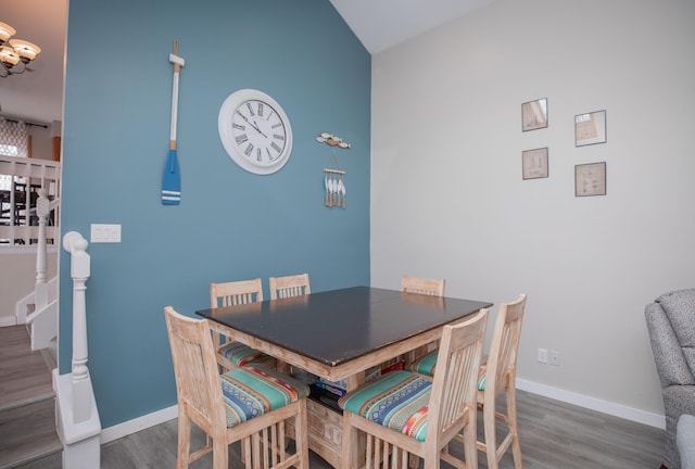 dining area with a notable chandelier, stairway, baseboards, and wood finished floors