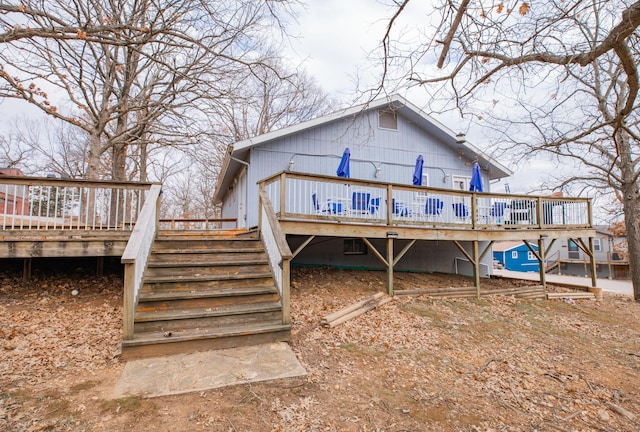 rear view of property featuring stairway and a wooden deck