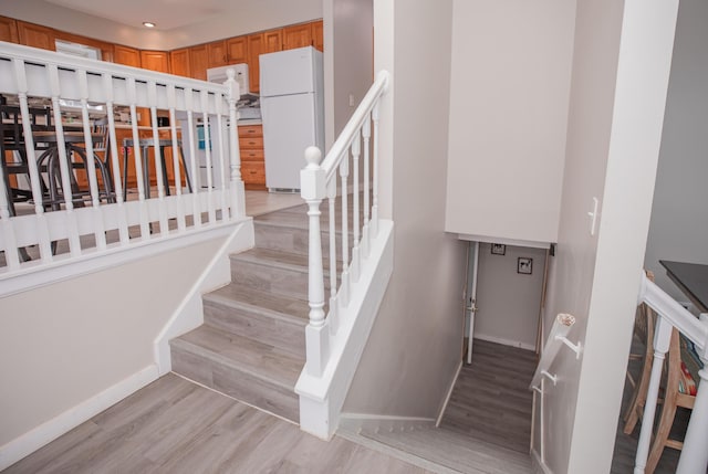 stairway with baseboards and wood finished floors