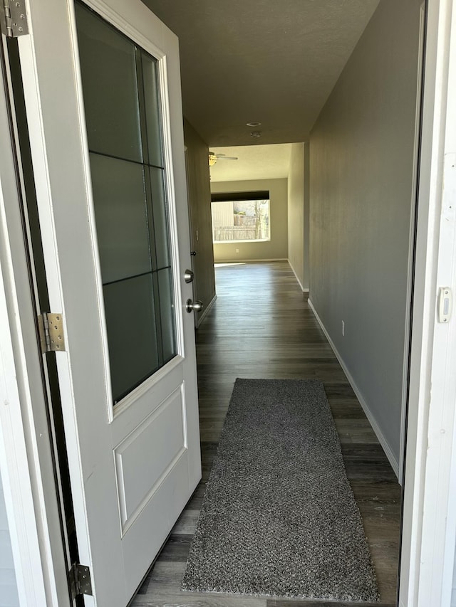 hallway with dark wood-style floors and baseboards